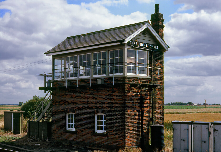 Three Horse Shoes signal box (GE, 1901) 
 The curiously named Three Horse Shoes signal box lies in an isolated Fenland spot between Whittlesey and March close to the village of Turves. Quite why it carries the name it does is a mystery, the only clue I can find is that there is a Horse Shoe Farm a short distance north of the box. In this 1981 view, the box is in its original condition as built by the Great Eastern in 1901 with its timber framed windows, a large chimney stack and wooden steps. Today, whilst it is still in operation, it has had the ghastly UPVC treatment making it almost unrecognisable, see..https://www.ontheupfast.com/p/21936chg/25696219604/x180109-09-49-london-king-s-cross 
 Keywords: Three Horse Shoes signal box