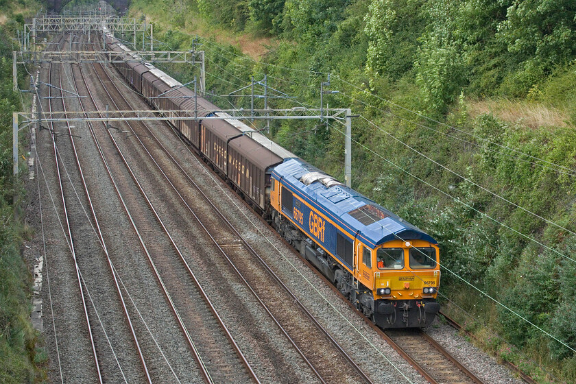 66795, 14.40 DIRFT-Dollands Moor (6O55, 4L), Hyde Road bridge 
 Namer 3 - 66795 'Bescot LDC'

GBRf's 6695 'Bescot LDC' looks very smart in contrast to the drab and work-stained Cargo Wagons it is hauling. The daily (seven days per week) 14.40 DIRFT to Dollands Moor empty wagons pass through Roade cutting. This is conveying the empty wagons back to the continent via the Tunnel for them to be filled with bottled water and return to the UK again for onward distribution from Daventry. 
 Keywords: 66795 14.40 DIRFT-Dollands Moor 6O55 Hyde Road bridge Bescot LDC GBRf