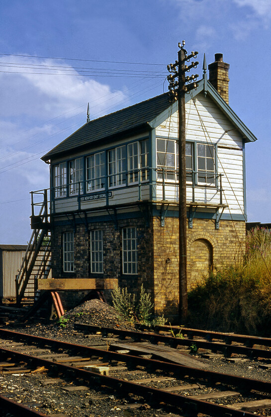 Croes Newydd East signal box 
 I have been able to glean very little information about Croes Newydd East signal box that is seen here basking in the afternoon summer sunshine. I am not even sure where it was located so would appreciate it if anybody could furnish me with any further information. It is a later and simpler GWR design with its gabled roof rather than the more common hipped design. It was switched out hence our bold trackside photograph that will have involved some sort of illicit access! Incidentally, notice that the nameplate on the box spells Croes Newydd as two words where as all the other boxes spell it as one! 
 Keywords: Croes Newydd East signal box