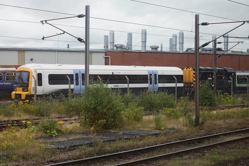 466012 & 08724, stabled, Doncaster yard 
 It looks as though Doncaster's Wabtec works is busy as stock from three different operators is seen in this image. To the left is a Great Eastern coach with one of London Midland's to the right. In the foreground, part of South Eastern's refurbished unit 466012 is being shunted by 08724 and looks ready to return to its operator following refurbishment. 
 Keywords: 466012 08724 Doncaster yard