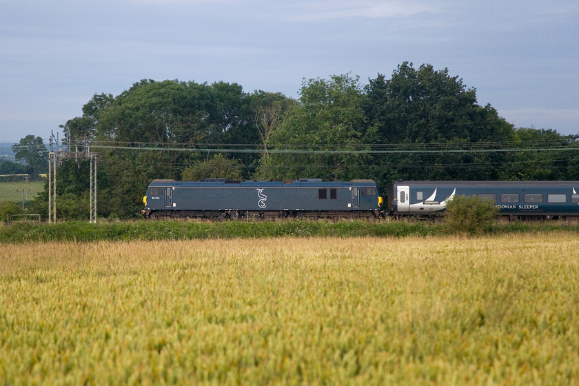 92014, CS 20.45 Inverness, 21.43 Aberdeen & 19.50 Fort William (1M16, RT), between Roade & Ashton 
 I photographed the same class 92 hauling the 1M16 sleeper a couple of Saturdays but in a very different location, see.... https://www.ontheupfast.com/p/21936chg/30057003034/x92014-20-45-inverness-21-43-aberdeen This time the side on view shows it passing close to home just across the fields of ripening wheat near Roade. Not the best colour to be photographed on a dullish summer's morning against a green background- thank goodness for the white flash on the leading coach! 
 Keywords: 92014 20.45 Inverness 21.43 Aberdeen 19.50 Fort William 1M16 between Roade & Ashton Caledonian Sleeper