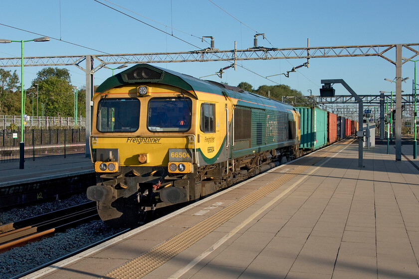 66504, 02.35 Garston-London Gateway (4L52, 11L), Bletchley station 
 After being checked at Milton Keynes by a southbound London NorthWestern unit the 4L52 Garston to London Gateway Freightliner was picking up speed here as it passes through Bletchley station. I think that the revised sweeping Freightliner livery as applied to 66504 seen here looks very smart keeping the locomotives looking fresh despite them being a design that dates back many years to 1986 when the almost identical looking Class 59s were introduced. 
 Keywords: 66504 02.35 Garston-London Gateway 4L52 Bletchley station Freightliner