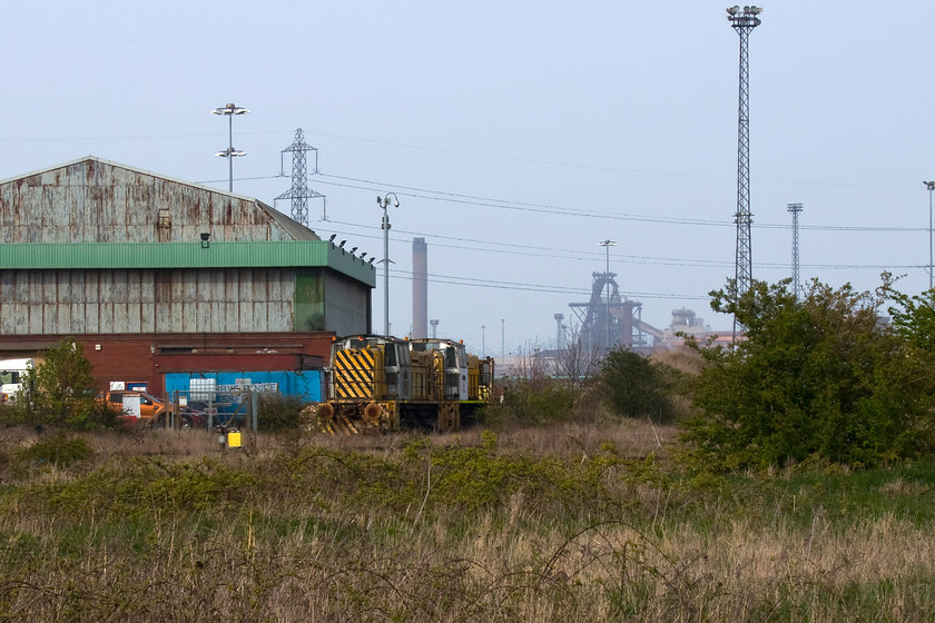 Shunters, stored, Redcar steelworks 
 With the blast furnace of the former Redcar steelworks dominating the skyline, two of the mothballed English Electric Stephenson 750bhp shunters are seen. The storage of these unidentified shunters actually predates the closure of the works having been taken out of service in 2010 when new NSB Di 8 shunters were introduced these being leased from Norwegian Railways. A desolate scene that acts as a reminder of our once proud industrial skills and heritage. 
 Keywords: Shunters stored Redcar steelworks