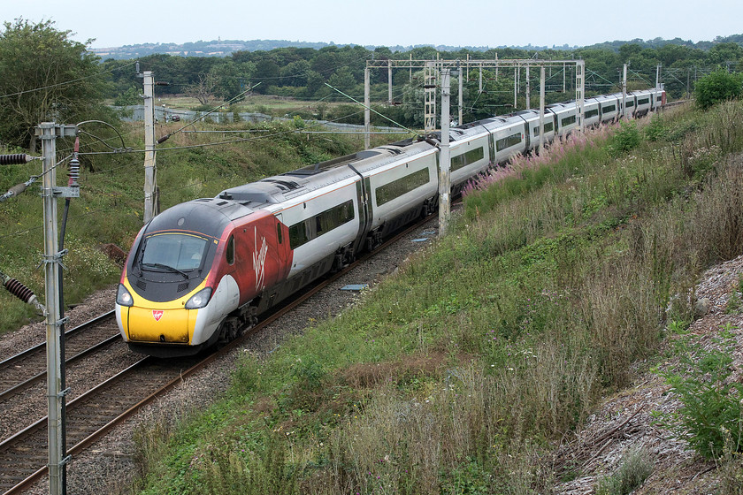 390117, VT 10.05 Wolverhampton-London Euston (1B08, RT), Milton Malsor SP738560 
 390117 'Blue Peter' forms the 10.05 Wolverhampton to Euston approaching Milton Malsor on the Northampton loop off the WCML. It will rejoin the route it would normally have taken in Roade cutting, about three miles away. Notice that the embankment is re-growing at an alarming rate having been completely cleared last winter. I suspect that by this time next year, this picture will have become almost impossible again. 
 Keywords: 390117 10.05 Wolverhampton-London Euston 1B08 Milton Malsor SP738560