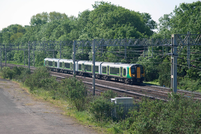 350103, LM 08.46 London Euston-Crewe (1U27), site of Roade station 
 350103 passes the site of Roade's old station on the down fast forming the 08.46 Euston to Crewe. The actual spot where the Desiro is passing is where Roade Junction signal box was located in a spot where the trees are now proliferating. 
 Keywords: 350103 08.46 London Euston-Crewe 1U27 site of Roade station