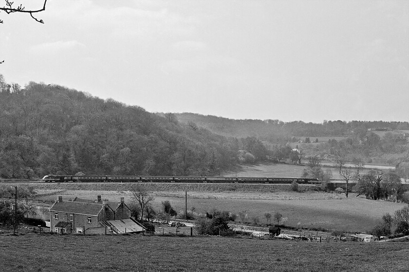 Class 43, diverted unidentified up working, Freshford ST800603 
 Looking across the Avon Valley near the village of Freshford a diverted HST is seen heading towards Paddington. It has just crossed a small viaduct with the River Avon going underneath just beyond which the Rover Frome joins. In the foreground is the curiously named Elbow Cottage with the Kennet and Avon Canal between it and the railway. Three cars are parked around the cottage, a Renault 4, a ubiquitous Cortina and a two door VW Golf Mk. 1. 
 Keywords: Class 43 unidentified up working Freshford ST800603 HST