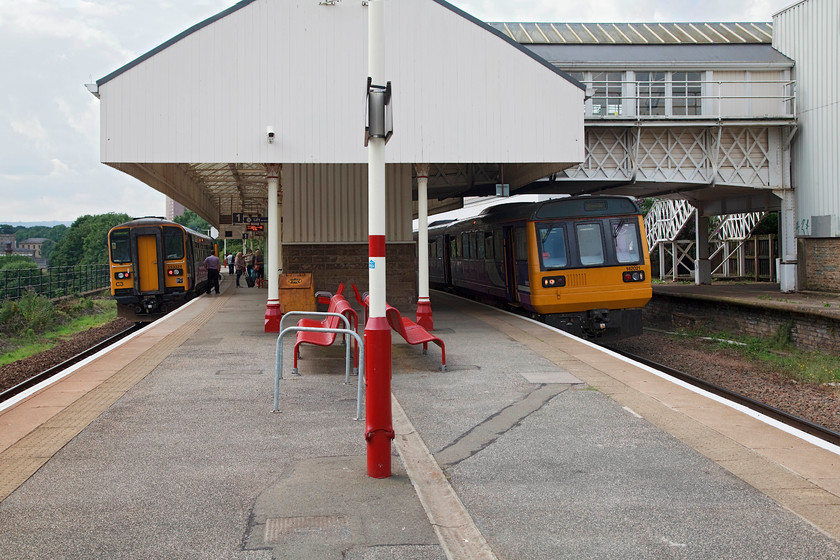 153324, NT 09.54 Hull-Huddersfield (2W69, 1E) & 142021, NT 10.50 Huddersfield-Leeds (2W70, RT), Halifax station 
 Halifax station is still largely extant but actual operations are a fraction of what they once were. There are only two platforms in use now but at least the signal box is operational. To the left, 153324 gets ready to leave working the 09.54 Hull to Huddersfield. Whilst, to the right, 142021 departs with the 10.50 Huddersfield to Leeds. I have just travelled on this train from Huddersfield. 
 Keywords: 153324 2W69 142021 2W70 Halifax station