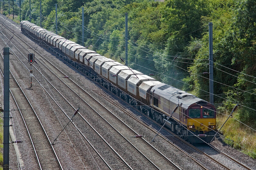 66037, 08.20 Middleton Towers-Monk Bretton Redfearns (6E84), Westby SK962271 
 A regular and interesting freight flow through from Norfolk to Yorkshire remains the so-named 'Redfears'. It's a heavy train that conveys sand from an extraction site just east of King's Lyn to a glass factory at Monk Bretton near Barnsley. It is seen slogging up Stoke bank near the village of Westby lead by 66037 running as the 6E84 that left Middleton Towers at 08.20. It is usually a week day service only occasionally running on Saturdays as seen here. 
 Keywords: 66037 08.20 Middleton Towers-Monk Bretton Redfearns 6E84 Westby SK962271 EWS