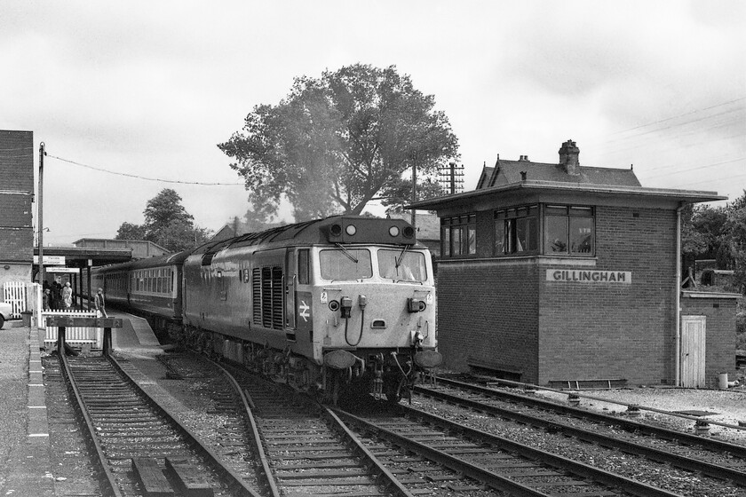 50011, 11.10 London Waterloo-Exeter St. David's (1V11), Gillingham station 
 The train service on the former L&SW route between Salisbury and Exeter on Sundays was pretty poor back in the 1980s with the large sections of the route undergoing singling. One of the few timetabled Sunday trains is seen standing at Gillingham station destroying the peace and quiet of a small Dorset town on a summer's afternoon! 50011 'Centurian' is seen next to the 1957 signal box leading the 1V11 11.10 London Waterloo to Exeter St. David's. 
 Keywords: 50011 11.10 London Waterloo-Exeter St. David's 1V11 Gillingham station Centurian