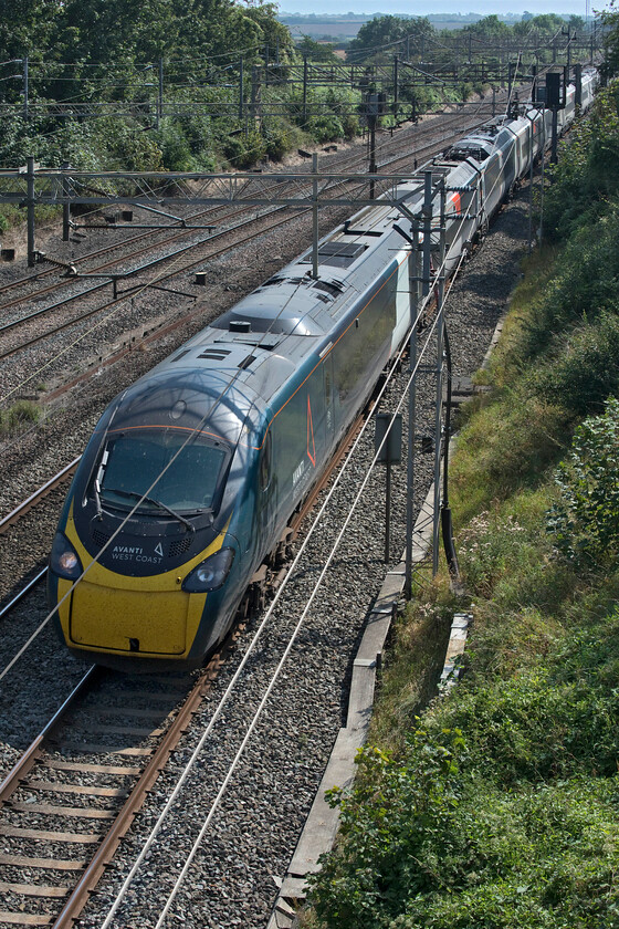 390127, VT 12.18 London Euston-Manchester Piccadilly (1H67, 1L), Victoria bridge 
 Under perfect blue skies and with a building temperature 390127 races through the Northamptonshire countryside. It is working the 12.18 Euston to Manchester 1H67 service past Victori bridge just south of Roade. 
 Keywords: 390127 12.18 London Euston-Manchester Piccadilly 1H67 Victoria bridge Avanti West Coast Pendolino