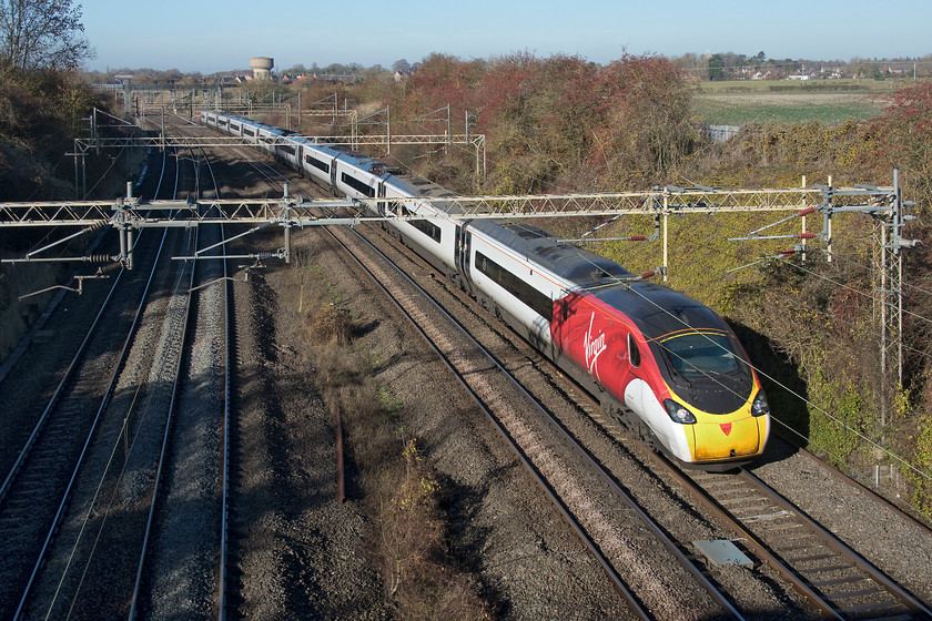 390117, VT 10.20 Manchester Piccadilly-London Euston (1A11, RT), Victoria bridge 
 390117 'Blue Peter' forms the 10.20 Manchester Piccadilly to London Euston past Victoria bridge near Roade. It is on the up slow line due to the Weedon Loop being closed for engineering works. This was the final up train to take the diversionary route as the Weedon Loop had just been handed back, the next up train appeared about five minutes after this picture was taken on the fast line. This is my first picture of 390117 since it was named a month earlier to mark 60 years of the children's TV programme of the same name. 
 Keywords: 390117 10.20 Manchester Piccadilly-London Euston 1A11 Victoria bridge