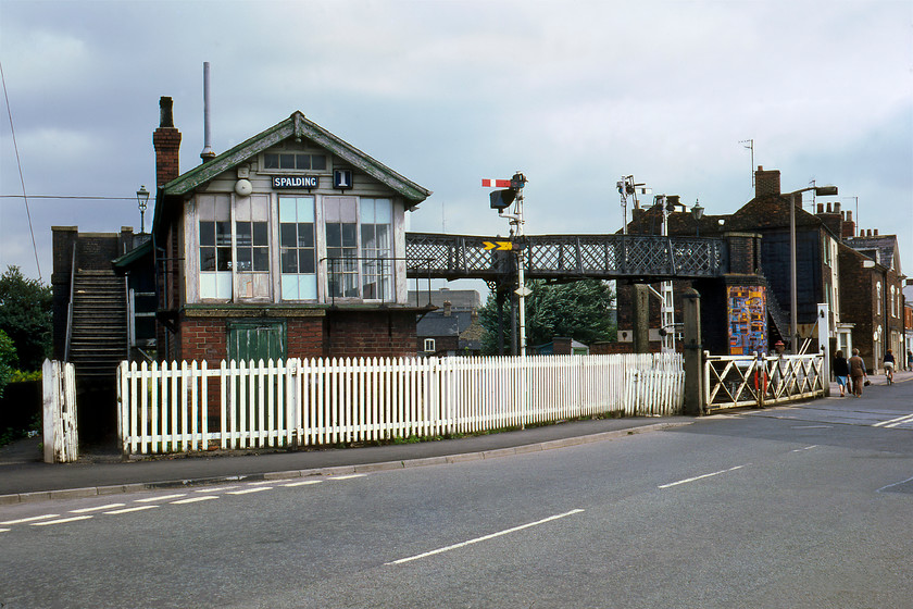 Spalding No. 1 signal box (GN, 1921) & gates 
 A scene familiar to many a Spalding resident over the years but one that has not looked quite like this for some time. Dominating the photograph is the magnificent Spalding No. 1 signal box constructed by the Great Northern in 1921 that originally controlled the station approach, the junctions with the Bourne, Wisbech and March lines and, of course, the level crossing over Winsover Road. Notice the brick base to the box that was constructed during the war as a blast protection measure with the timber base behind it. There is so much railway infrastructure in this that dates from another era for example notice the two gas lamps on the footbridge and the LNER signal box nameplates. 
 Keywords: Spalding No. 1 signal box (GN, 1921) gates Great Northern Railway