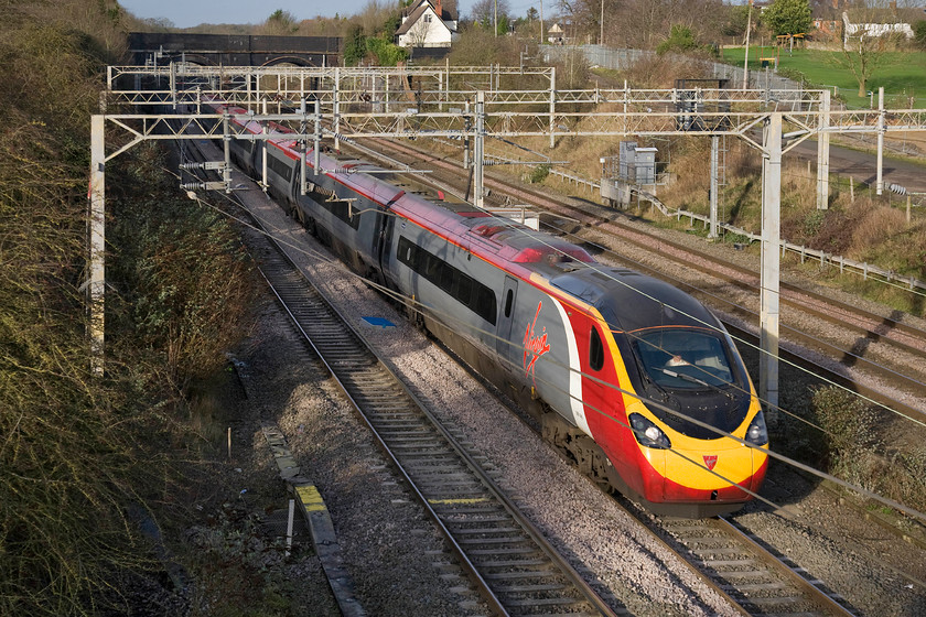 390040, VT 10.10 Liverpool Lime Street-London Euston (1A20), site of Roade station 
 390040 'Virgin Pathfinder' emerges into the winter brightness at Roade with the driver no doubt squinting as a result of the sun's low angle. The Virgin Pendolino is working the 10.10 Liverpool Limes Street to Euston 1A20 service. 
 Keywords: 390040 10.10 Liverpool Lime Street-London Euston 1A20 site of Roade station Virgin Trains VT Pendolino Virgin Pathfinder