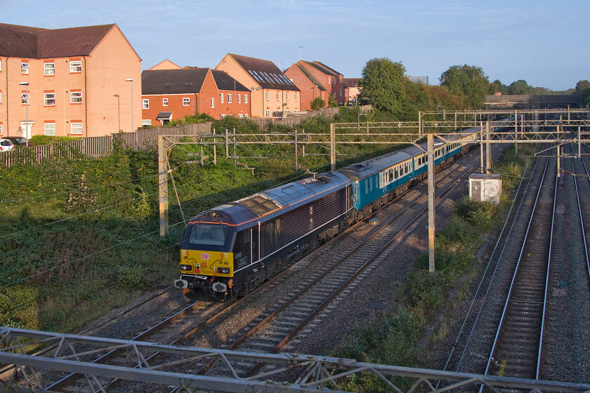 67005, outward leg of The Snowdonian, 06.51 London Euston-Bangor (1Z67, RT), site of Roade station 
 67005 'Queen's Messenger', along with 67007 (out of sight and leading) has become the regular 'go-to' 67s used on charter traffic. Bringing up the rear of The Snowdonian charter that left Euaton at 06.51 and, appropriately, running as 1Z67 67005 is seen passing through Roade in the early morning September light. Notice my shadow on the extreme left of the frame as I lean over the parapet of the bridge on my steps to capture the scene! 
 Keywords: 67005 The Snowdonian, 06.51 London Euston-Bangor 1Z67 site of Roade station Queen's messenger UKR UK Railtours