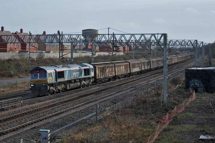 66747, 06.53 Dollands Moor-DIRFT (6M45, 15L), site of Roade station 
 Making a change the 6M45 Dollands Moor to Daventry 'water train' is today hauled by GBRf's (but with Newell & Wright branding) 66747 'Made in Sheffield'. This is a DB Cargo-operated train but of late they have been hiring in GBRf locomotives on a regular basis. The train is seen passing through Roaderather sid lit by the welcome winter sunshine. 
 Keywords: 66747 06.53 Dollands Moor-DIRFT 6M45 site of Roade station Water train Made in Sheffield