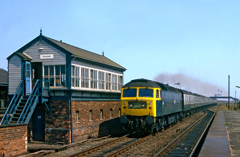 47090, excursion from Shoeburyness (1ZXX), Abergele & Pensarn station 
 Apologies again for the poor colour rendition of the Fujchrome 100 slide film that has not stood the test of time well! 47090 'Vulcan' is seen racing past Abergele signal box leading an excursion from Shoeburyness. I am not sure where it was heading but it was probably to Llandudno. Whilst the station was named Abergele and Pensarn (from 1883) the 1902 L&NWR Type 4 box was simply called Abergele until it was refurbished in the mid-2000s when a reproduction LMS wooden nameboard was applied carrying the same name as the station. 
 Keywords: 47090 Shoeburyness 1ZXX Abergele & Pensarn station Vulcan