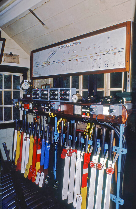 Interior, Salisbury Tunnel Junction signal box (LSW, c.1870) 
 Salisbury Tunnel Junction signal box contained a large, for the size of the box that is, Stevens & Sons lever frame that grew over time eventually topping out at twenty-one levers as seen here. As can be seen, this filled the box with very little space to spare. It operated absolute block through Fisherton tunnel to Salisbury East and as far as Dean on what was referred to as the 'branch' but was in fact the route to Portsmouth and Southampton. On the afternoon of my visit just nine days prior to its closure a signalman, Reg, of some forty-five years service was on his last shift before retirement. I have a cassette recording of him finishing his six to two shift by ringing the bells after signalling his last train and handing over to his relief with the poignant words said in his rich Wiltshire accent, 'There you go, it's all yours'! With that done, he exited the box, climbed on his ancient bike and rode home; the end of an era. 
 Keywords: Interior Salisbury Tunnel Junction signal box 1870 L&SWR London and South Western Railway