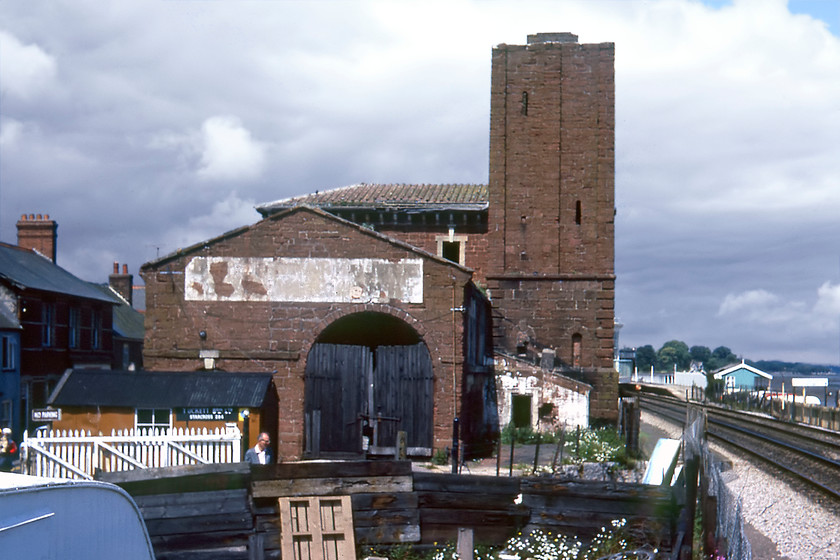 Brunel Atmospheric Pumping House, Starcross 
 Even the great Brunel had some failures! One of his inventions that was ultimately flawed was the atmospheric railway that he developed between Exeter and Newton Abbot with plans to extend it to Torquay, Totnes and beyond. Of the eight engine houses built to power the atmospheric railway two remain intact. The Starcross engine house is located next to the station sandwiched between the railway and the A379 road through the village. Back in 1980 it was derelict and looking a bit sorry for itself but it has since been renovated and is now in use by the Starcross Fishing and Cruising Club. The chimney of this engine house was shortened at some time in the past and is about one half the height of what it was. 
 Keywords: Brunel Atmospheric Pumping House Starcross