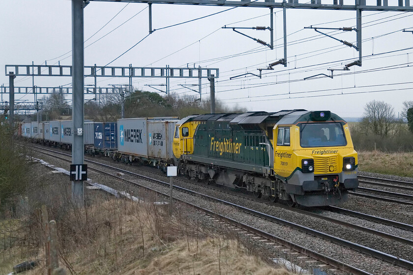 70019, down Freightliner, Ashton Road bridge 
 Class 70s are not particularly common on the southern section of the WCML with them making their presence known when they do operate! 70019 passes just south of Roade working an undidentified down Freightliner service. 
 Keywords: 70019 down Freightliner Ashton Road bridge