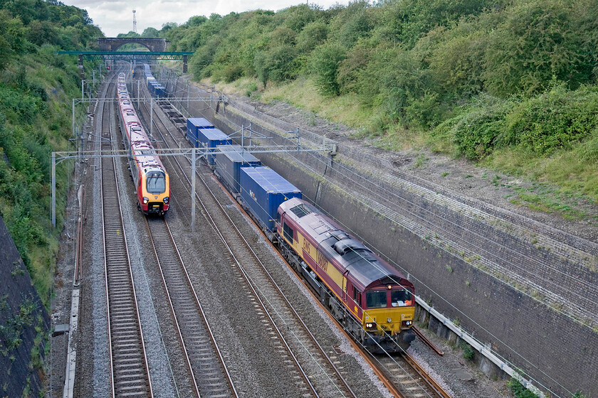 Class 221, VT 12.00 Glasgow Central-London Euston (9M55) & 66087, 15.36 Hams Hall-Dollands Moor, Roade cutting 
 An unidentified Class 221 Voyager is about to pass the 15.36 Hams Hall to Dollands Moor Freightliner. The Voyager is approaching the end of its journey as the 12.00 Glasgow to Euston whilst 66087 is leading the Freightliner. Unfortunately, despite the generally sunny afternoon, this is the only photograph taken in the shade of a cloud? 
 Keywords: Class 221 12.00 Glasgow Central-London Euston 9M55 66087 15.36 Hams Hall-Dollands Moor Roade cutting Virgin Voyager EWS Freightliner