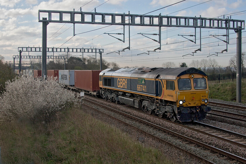 66741, 03.10 Felixstowe North-Trafford Park (4M21, 5E), Ashton Road bridge 
 Unfortunately, the sun has again dived behind some troublesome cloud weakening the cold early morning light somewhat. 66741 'Swanage Railway' approaches Roade leading GBRf's operated 4M21 03.10 Felixstowe to Trafford Park service. With the hawthorn (Crataegus) in full flower, it can only be early spring but on this particular morning, it did not feel spring-like due to it being particularly cold! 
 Keywords: 66741 03.10 Felixstowe North-Trafford Park 4M21 Ashton Road bridge Swanage Railway