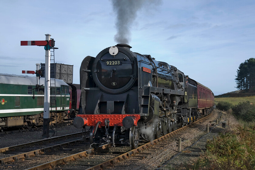 D5631, stabeld & 92203, 10.30 Sheringham-Holt, Weybourne station 
 A fine study of 9F 92203 'Black Prince' as it makes its final approach to Weybourne station leading the 10.30 Sheringham to Holt North Norfolk Railway service. In this view, the bulk of the locomotive can really be appreciated with its twenty by twenty right inch cylinders and its huge five feet diameter driving wheels. To the left of the train is Class 31 D5631 that looks very smart in its British Railways green livery. 
 Keywords: D5631 92203 10.30 Sheringham-Holt Weybourne station Black Prince