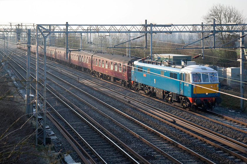 86259, outward leg of The Cumbrian Mountain Express, 07.10 London Euston-Carlisle (1Z86), Hungate End SP784465 
 Not my finest shot of 86259 'Peter Pan/Les Ross' working the Cumbrian Mountain Express railtour from Euston to Carlisle. However, because of the sheer effort I put into getting it because of the extreme cold I am going to include it! Normally, the wires would not intrude in this shot; I have taken many here before. Because of the low sun angle reflecting off them they do spoil the shot somewhat! 
 Keywords: 86259 The Cumbrian Mountain Express 1Z86 Hungate End SP784465