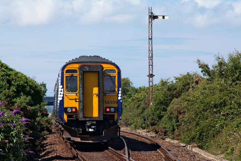 156509, SR 11.04 Kilmarnock-Stranraer (1A64, RT), Dunragit NX152572 
 156509 working the 11.04 Kilmarnock to Stranraer is slowing for its brief stop at Dunragit to facilitate the token exchange. After it had passed, I took the opportunity to access a small foot crossing to capture it passing the up GSW up lattice signal. 
 Keywords: 156509 1A64 Dunragit NX152572