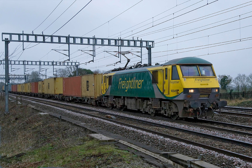 90049, 03.09 Felixstowe North-Ditton (4M45), Ashton Road bridge 
 90049 passes between Roade and Ashton on the southern WCML leading the 4M4 03.09 Felixstowe to Ditton Freightliner service. On this grey and dark March morning, I was pushing the capabilities of the camera somewhat meaning that I needed to undertake a fair bit of digital tinkering. 
 Keywords: 90049 03.09 Felixstowe North-Ditton 4M45 Ashton Road bridge Freightliner