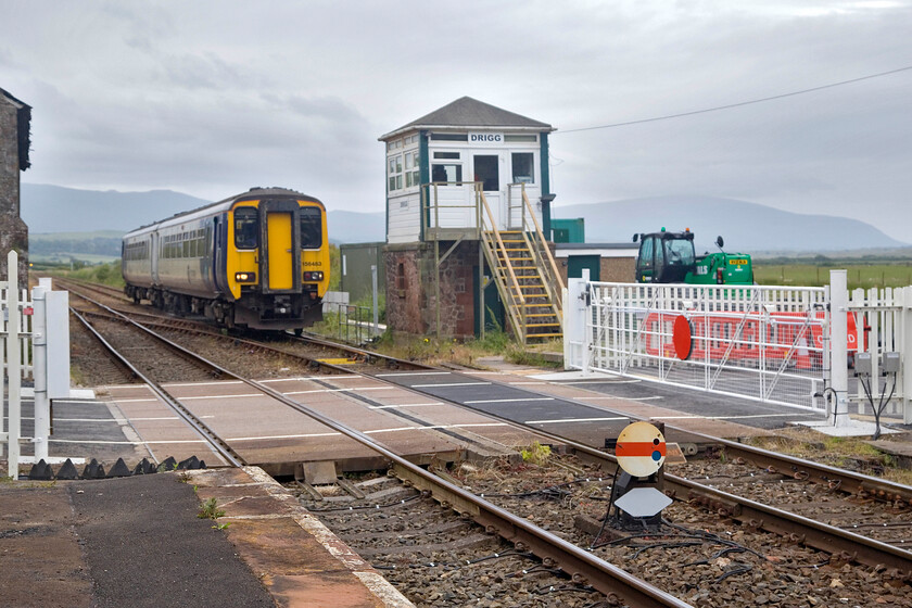 156483, NT 14.49 Barrow-in-Furness-Carlisle (2C59, RT), Drigg station 
 A gloomy day at Drigg with the fells shrouded in mist! 156483 works the 14.49 Barrow-in-Furness to Carlisle service through the station passing the 1871 Furness signal box. Much recent work was evident at the level crossing with new manual gates installed and the road surface re-laid. 
 Keywords: 156483 14.49 Barrow-in-Furness-Carlisle 2C59 Drigg station Northern