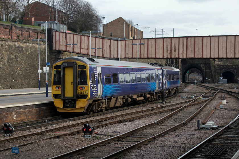 158871, NT 15.04 Leeds-Nottingham (1Y23, 1L), Sheffield station 
 158871 leaves Sheffield working the 15.04 Leeds to Nottingham. This 1Y23 service runs fast from Leeds via Wakefield Kirkgate and Barnsley. It then runs through to Chesterfield, Alfreton and Ilkeston. Notice the catenary of the Sheffield tram system as it crosses Shrewsbury Road before heading aside Granville Street. 
 Keywords: 158871 15.04 Leeds-Nottingham 1Y23 Sheffield station