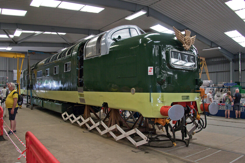 55015, on display, DPS Depot, Barrow Hill 
 Work to completely rebuild 55015 'Tulyar' is nearing completion inside The Deltic Preservation Society's depot at Barrow Hill. Work to get it to this stage has taken many years and a huge amount of money but with the end in sight it will once again be seen out on heritage lines and ultimately working on the mainline. The engines have yet to be installed but have been rebuilt with the bogies the next major thing to be reunited with the shell. The enthusiast in the yellow top to the left is looking at the rebuilt bogies. When in use and prior to withdrawal I saw and photographed 55015 a number of times with one of my most atmospheric images recorded at King's Cross in November 1979, see.... https://www.ontheupfast.com/p/21936chg/27444295204/x55015-21-00-london-king-s-cross 
 Keywords: 55015 on display DPS Depot Barrow Hill Deltic Preservation Society Tulyar