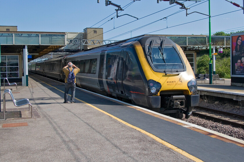 221117, VT 12.49 Holyhead-London Euston (1A50, 3L), Milton Keynes Central station 
 Andy did not take his rather heavy and cumbersome steam-powered Canon D60 with him on this day which was probably a good idea given the long walk that we had taken following the Nickey Line earlier in the day. As an alternative, he made good use of his iPhone and is seen here videoing AWC's 221117 entering Milton Keynes working the 12.49 Holyhead to Euston service. Apologies for taking this image of what is rather mundane a train (a Voyager) on the wrongs side for the sun but I take any opportunity to capture them now that they are in their final few months of operation on the WCML route, soon the sounds of their horrendous 750hp Cummins QSK19 engines will no longer be passing my home in Roade! 
 Keywords: 221117 12.49 Holyhead-London Euston 1A50 Milton Keynes Central station AWC Avanti West Coast Voyager