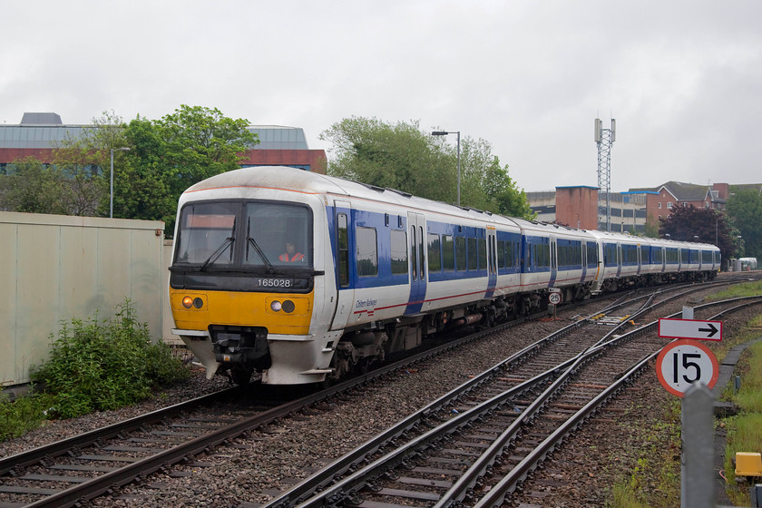 165028 & 165030, ECS, Aylesbury station 
 A five-car ECS formation draws into Aylesbury station formed of 165028 and 165030. This is a scene that has changed dramatically over the years that I have been visiting Aylesbury. Behind the hoarding to the left is a huge car park, that used to be covered with an extensive complex of carriage sidings all controlled by mechanical signalling. 
 Keywords: 165028 165030 ECS Aylesbury station