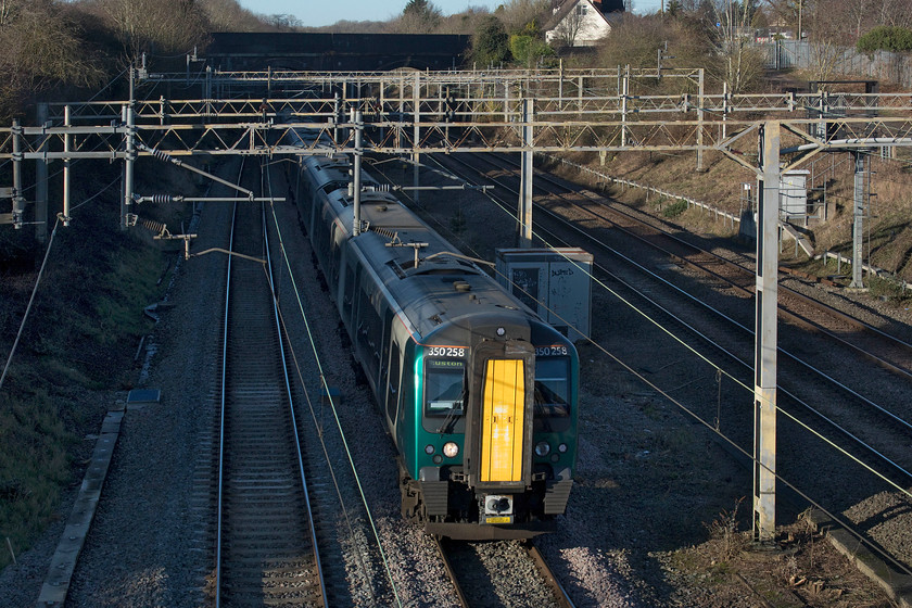 350258, LN 12.16 Crewe-London Euston (1U30, 1E), site of Roade station 
 350258 emerges from Roade cutting into the winter sunshine working the 12.16 Crewe to Euston service. It has just taken the Northampton avoider line from Hilmorton Junction south of Rugby and will now run on the up fast all the way to its destination stopping just once at Milton Keynes. 
 Keywords: 350258 12.16 Crewe-London Euston 1U30 site of Roade station London Northwester Desiro