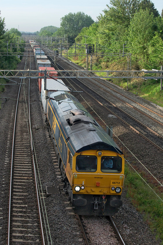 66712, 03.15 Felixstowe North-Trafford Park (4M21), Victoria bridge 
 66712 'Peterborough Power Signalbox' leads the regular 4M21 013.15 Felixstowe North to Trafford Park Freightliner past Victoria bridge between Northampton and Milton Keynes. Notice the nonchalant driver sitting at his controls with his arms folded! 
 Keywords: 66712 03.15 Felixstowe North-Trafford Park 4M21 Victoria bridge