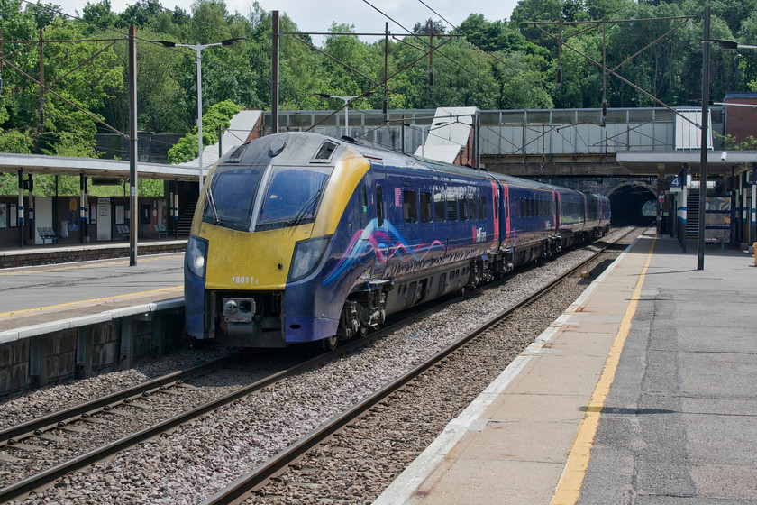 180111, HT 13.48 London King`s Cross-Hull (1H04, 2L), Hadley Wood station 
 180111 gets into its stride as it heads north through Hadley Wood station forming the 13.48 King's Cross to Hull service. The train has just emerged from Hadley Wood south tunnel that was opened in the 1890s some thirty years after the left-hand tunnel (out of sight behind the train) was completed. This was when the track was quadrupled as the original double track layout was prooving inadequate. It is said that Hadley Wood has such a large station, totally out of proportion to the area it serves, as one local resident was no less than Sir Nigel Gresley! 
 Keywords: 180111 13.48 London King`s Cross-Hull 1H04 Hadley Wood station