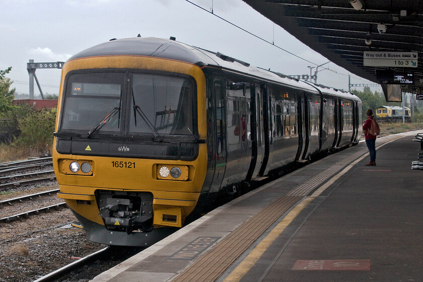 165121, GW 14.04 Didcot Parkway-Banbury (2M38, 3L) & 66418, 10.59 Lawley Street-Southampton MCT (4O03, 4E), Didcot Parkway station 
 Connecting with the 13.49 arrival from Paddington the 14.04 to Banbury GWR service waits to depart from Didcot. With the doors open the passenger standing on the platform seems reluctant to board the train seemingly more interested in the passing of the 4O03 Freightliner on the relief line. Unfortunately, Mike, who has access to TOPS via Freightmaster, was unable to identify the locomotive hauling the freight but by chance, a week after our visit, Mark Pye placed his Oxford spotting log from this day on the forums so I can state that the locomotive is 66418 'Patriot - In Memory of Fallen Railway Employees'. 
 Keywords: 165121 14.04 Didcot Parkway-Banbury 2M38 66418 10.59 Lawley Street-Southampton MCT 4O03 Didcot Parkway station Patriot - In Memory of Fallen Railway Employees