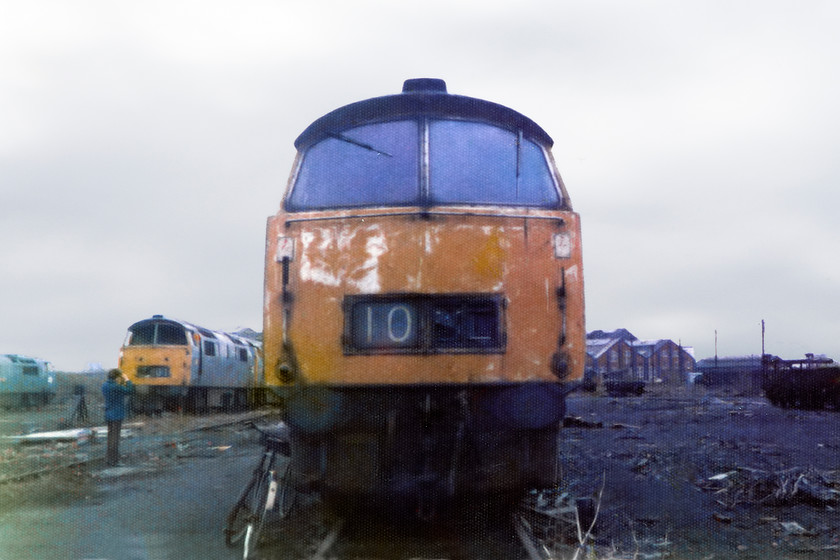 D1057 & D1065, scrap line, Swindon Works 
 Having covered one point two million miles in its fourteen-year working life D1065 'Western Consort' looks sorry for itself in the scrap-line at Swindon Works. D1057 'Western Chieftain', minus both windscreens, is seen to the left. The bike leaning against D1065 was used by the guide who showed us around the works. He walked it the entire time whilst a cigarette dangled from the corner of his mouth talking with a strong Swindon drawl!

The next time that I would photograph a locomotive with the same name would be some fort seven years later, see...... https://www.ontheupfast.com/p/21936chg/30058144615/x3-69009-458410-13-11-widness-transport 
 Keywords: D1065 Western Consort D1057 Western Chieftain Swindon Works scrap lines