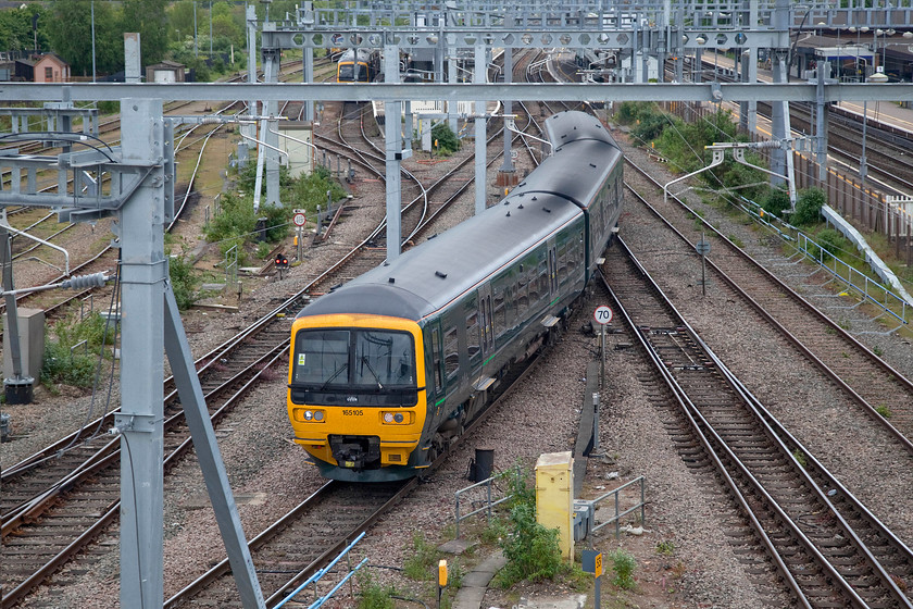 165105, GW 11.28 London Paddington-Oxfrod (2N32, 2L), Didcot Parkway temporary car park footbridge 
 The electrification paraphernalia that has completely taken over at Didcot station is clear in this picture. 165105 winds its way through the chaos at the western end of the station working the 11.28 Paddington to Oxford service. The picture is taken from the vantage point created by the construction of a temporary footbridge to allow access to the massive new car park. 
 Keywords: 165105 2N32 Didcot Parkway