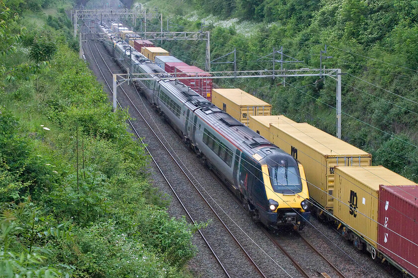 221110 & 221105, VT 14.48 Holyhead-London Euston (1A62, 2E) & 12.57 London Gateway-Garston (4M56, 19E), Hyde Road bridge 
 As the 4M56 Freightliner passes through Roade cutting 221110 and 221105 head south working Avanti's 14.48 Holyhead to Euston service. This photograph was taken the week the first Class 805s entered revenue service with a number of Class 221 diagrams going over to the new units. After twenty-two years of working the West Coast route time is finally being called on this noisy, cramped and pretty unpleasant units! Notice the wipers of 221110 in mid sweep indicating that it was now raining. 
 Keywords: 221110 221105 14.48 Holyhead-London Euston 1A62 12.57 London Gateway-Garston 4M56 Hyde Road bridge AWC Avanti West Coast Voyager