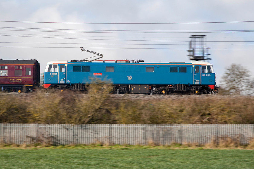 86259, outward leg of the Cumbrian Coast Express, 07.10 London Euston-Carlisle (1Z86), Milton Crossing 
 86259 'Les Ross/Peter Pan' leads the 1Z86 Cumbrian Coast Express past Milton Crossing just north of Roade Cutting. The veteran class 86 is a dependable performer on this working that it hauls as far as when the steam takes over. On this particualr ocassion, it gave way to class 7P 4-6-0 no 46100 'Royal Scot' at Carnforth that led to Carlisle and then back via the Cumbrian Coast route. 
 Keywords: 86259 outward leg of the Cumbrian Mountain Express 07.10 London Euston-Carlisle 1Z86 Milton Crossing