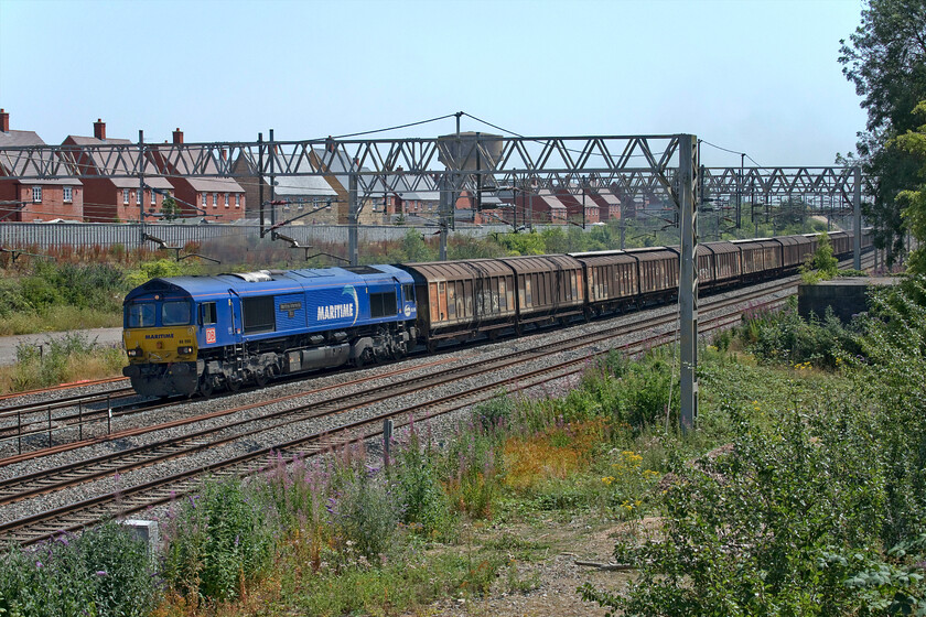 66090, 06.53 Dollands Moor-DIRFT (6M45, 12L), site of Roade station 
 My second trip out on the hottest day ever recorded in the UK finds me at the site of Roade station. Smoking badly (actually considerably worse than in this photograph) 66090 'Maritime Intermodal Six' leads the 6M45 06.53 Dollands Moor to Daventry daily bottled water train. Now I like the heat but I have to say that the intensity on this particular afternoon was quite extraordinary with my thermometer peaking at 39.2 degrees C not long after this photograph was taken. 
 Keywords: 66090 06.53 Dollands Moor-DIRFT 6M45 site of Roade station