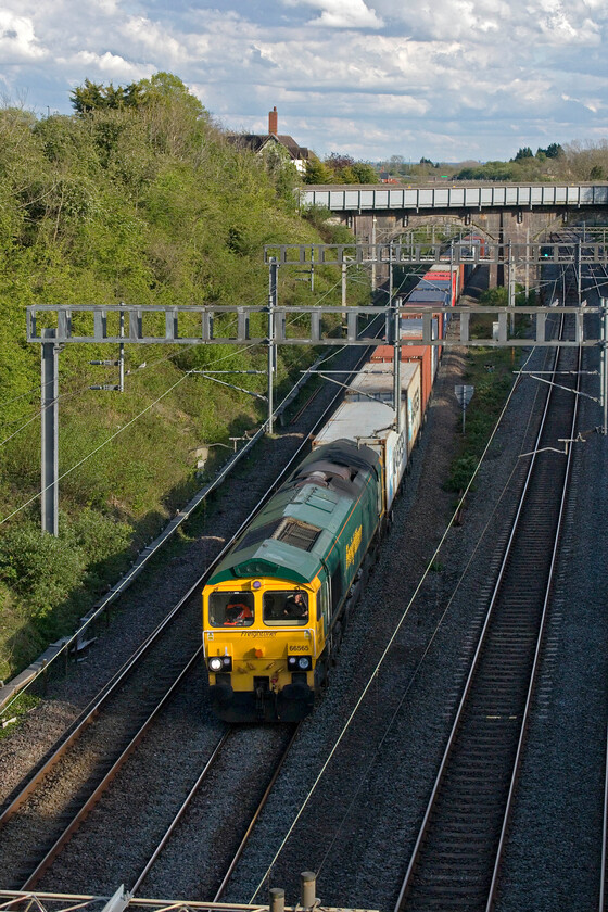 66565, 13.13 Felixstowe North-Lawley Street (4M93, 6L), Hyde Road bridge 
 Turning the camera to the portrait position lends itself to better framing in this rather confined location at the very southern end of Roade cutting. The resultant image sees Freightliner's 66565 leading the 13.13 Felixstowe to Lawley Street 4M93 service. The white building with the rather tall chimney to the top left is the former station master's house located at the top of the access road to the former station that closed in September 1964. 
 Keywords: 66565 13.13 Felixstowe North-Lawley Street 4M93 Hyde Road bridge Freightliner