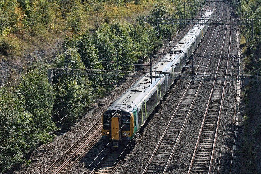 350103 & 350265, LN 11.24 London Euston-Birmingham New Street & Crewe (2Y11, 3L), Roade Cutting 
 A two-set class 350 combination passes through Roade Cutting that will split at Northampton station. 350103 leads whilst 350265 is at the rear forming the 11.24 Euston to Birmingham New Street and Crewe. In this view it is clear that the work undertaken to stabilise the face of the cutting a few years ago maybe in need of some urgent attention again soon. Notice the line of Ash trees that seem to be taking over and are probably doing their best undermine the base of the face. 
 Keywords: 350103 350265 2Y11 Roade Cutting