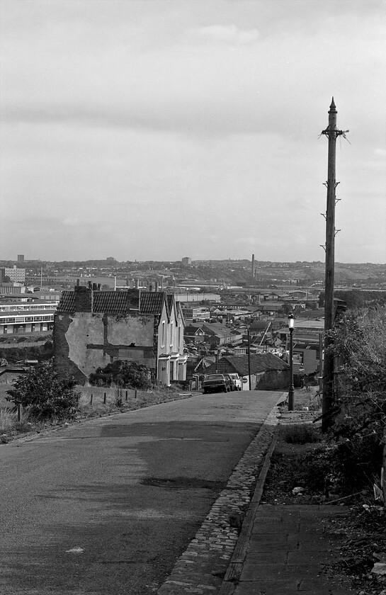 St Philip's Marsh from Highgrove Street 
 A photograph that clearly illustrates the urban dereliction that afflicted Bristol, and many other UK cities during this era for that matter. It is a view looking down Highgrove Street in Totterdown with just three houses remaining. Using Google Street View reveals that this street still exists complete with the cobbled gutters but the only building standing to identify it is the rectangular building directly behind the line of period cars with the no entry sign in front of it. Of railway interest is the St. Philips Marsh depot to the left of and behind the three houses and a number of DMUs stabled directly above the illuminated street lamp. 
 Keywords: St Philip's Marsh from Highgrove Street Bristol Totterdown