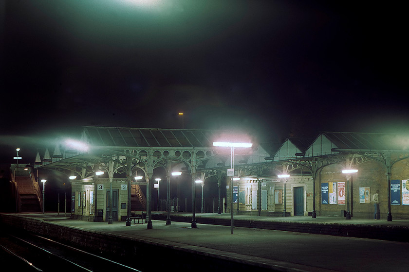 Elstree station 
 I like taking time exposures and in the days before digital photography as it was an activity that required considerable skill if one was to avoid wasting expensive Kodachrome 64 slides! Exposure times using 64ASA film at night obviously required a good tripod and a cable release to avoid camera shake from keeping the shutter release button depressed for some lengths of time. An exposure like this would have been in the region of thirty seconds using a medium aperture of something such as f8. By scanning the slides digitally I have been able to alter the colour temperature hue created by the ambient lighting. In the case of this image, largely illuminated by fluorescent lighting, there was a blue/green cast with the image presented here now having largely neutral lighting 
 Keywords: Elstree station