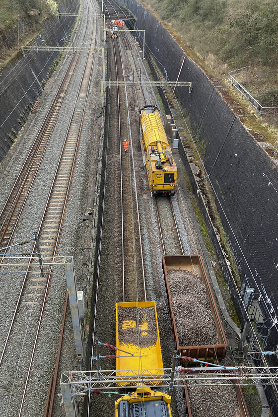 Trackwork, Roade cutting 
 The machine centre stage in this image taken in Roade cutting is a Railvac. This extraordinary piece of plant is a giant vacuum cleaner that essentially sucks up the ballast that can then be transferred to the waiting wagons to be taken away to Bescot for cleaning and then reuse. In the meantime, fresh ballast is laid down and the track reprofiled to specification. 
 Keywords: Trackwork Roade cutting