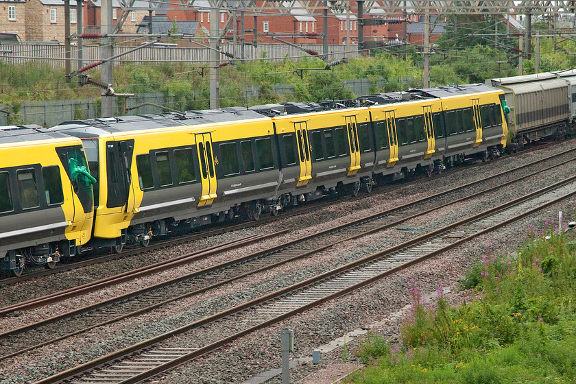 777005 & 777009, 02.44 Dollands Moor-Kirkdale (6X29, 5L), site of Roade station 
 A close up of new Merseyrail unit 777009 (with 777005 just going out of shot) passing Roade being dragged to its new home running as the 6X29 02.44 Dollands Moor to Kirkdale. The delivery of these Stadler built units is now chronically late in part due to the COVID-19 pandemic but, more importantly, because of software issues with the units on testing. Is it me or does this issue afflict all new trains these days? Notice that the driver's door of 777005 is partially open. Given the heavy and persistent rain experienced I hope that the dampness has not got into the cab and interfered with the very sensitive electrics and software creating further problems! 
 Keywords: 777005 777009 02.44 Dollands Moor-Kirkdale 6X29 site of Roade station Merseyrail Stadler