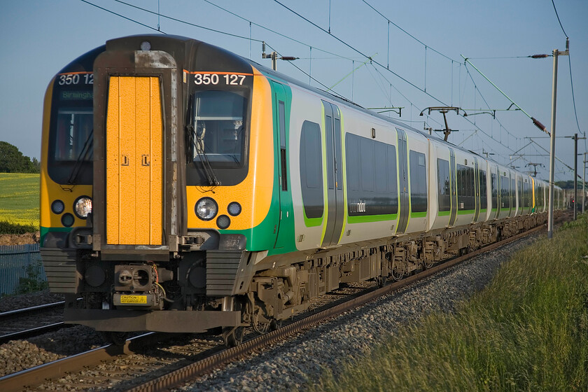 350127, LM, 18.49 London Euston-Birmingham New Street (1Y73), Milton Malsor SP740553 
 In the warm evening midsummer sunshine 350127 and a fellow Desiro pass Milton Malsor working the 18.49 Euston to Birmingham New Street service. The 1Y73 working is one a number that come quickly and fast between 17.00 and 20.00 bringing thousands of commuters back from London. 
 Keywords: 350127 18.49 London Euston-Birmingham New Street 1Y73 Milton Malsor SP740553 London Midland desiro